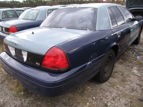 1991 Ford LTD Crown Victoria - A fleet of dark blue and light blue Ford Crown Victorias are parked in an outdoor lot.