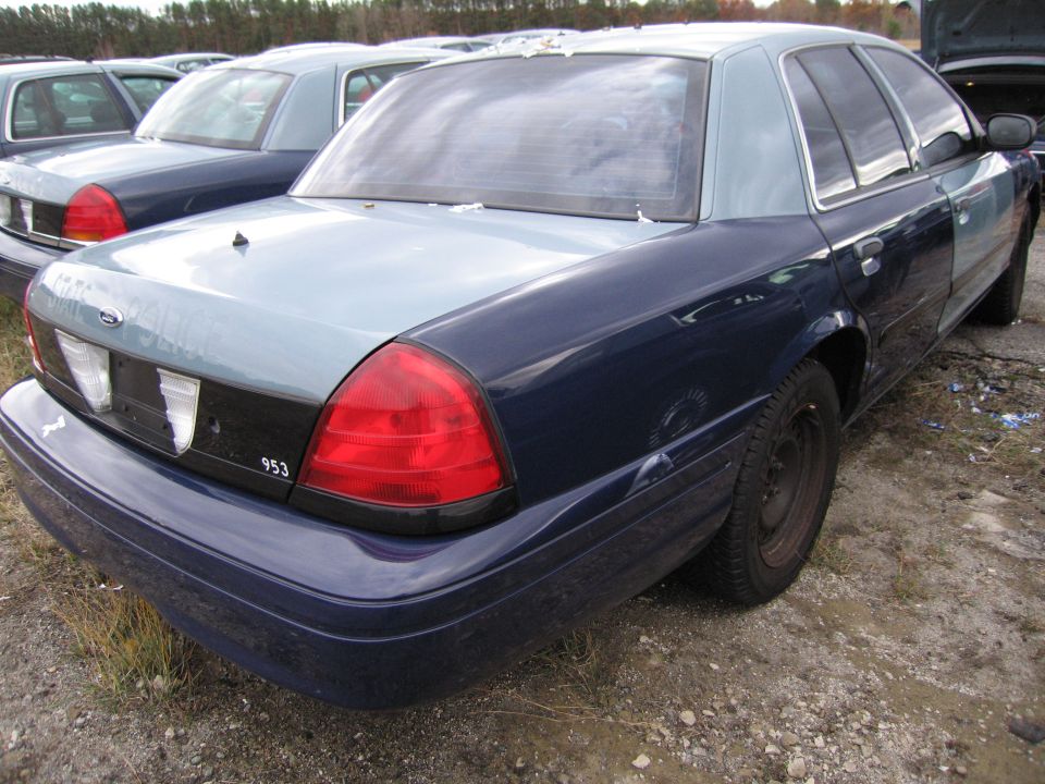 Dark blue and light blue 1991 Ford Crown Victoria LTD with a black grille panel and red taillights, seen from the rear