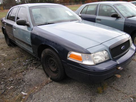 1991 Ford LTD Crown Victoria - This Ford Crown Victoria displays a two-tone paint scheme with panels of different colors, suggesting repairs or modifications.