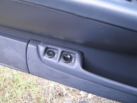 1991 Ford LTD Crown Victoria - Close-up of the interior door panel showing the fuel and trunk release buttons.