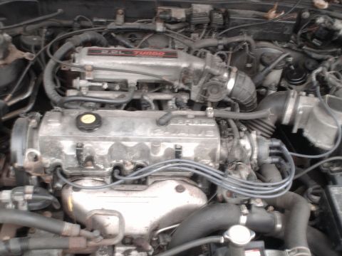 1996 Ford Probe - Close-up view of a vehicle's engine bay, highlighting the intake manifold and cylinder head.