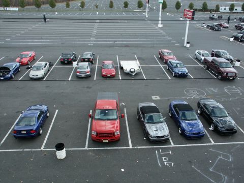 2001 Mercury Grand Marquis - A wide view of a parking lot filled with various vehicles, including a group of Ford Mustangs.
