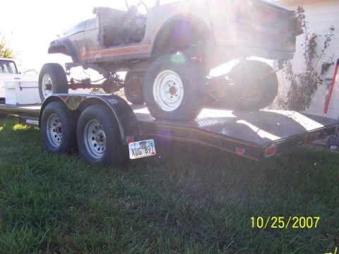 1995 Ford Bronco - This Jeep CJ-7 is being transported on a trailer, showing its frame and body panels.