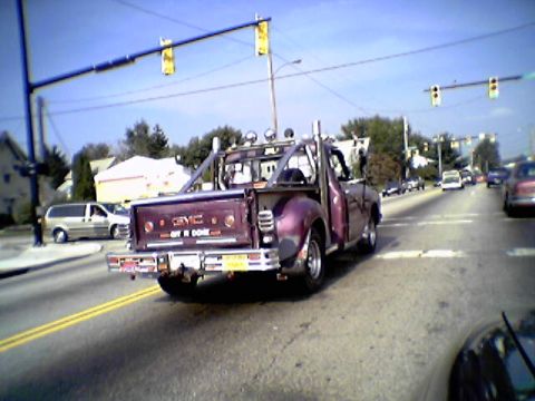 1970 Ford Ranchero - Customized GMC pickup truck with "OFF R DONE" on tailgate, seen from behind on a road.