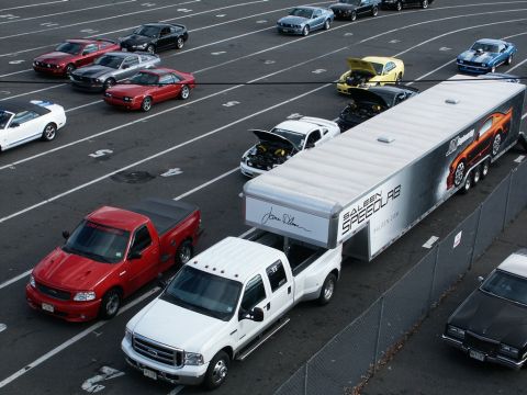2001 Mercury Grand Marquis - A collection of vehicles and a large trailer are parked on a track with numbered lanes.