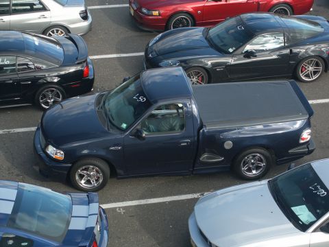 2001 Mercury Grand Marquis - A dark blue pickup truck with a tonneau cover is parked among other vehicles.