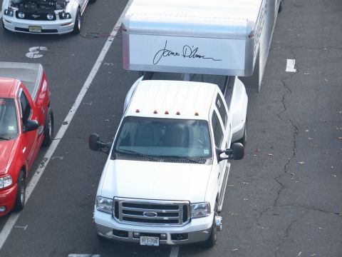 2001 Mercury Grand Marquis - A white Ford Super Duty truck tows a trailer, with other vehicles visible in the background.