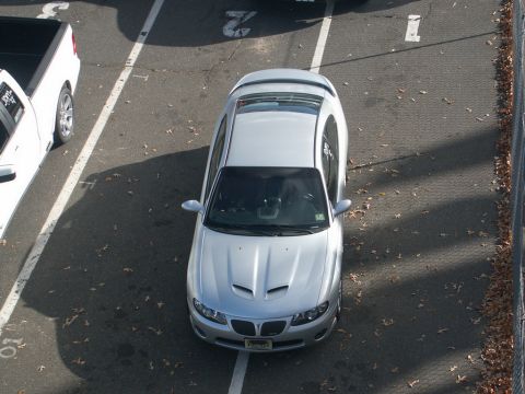 2001 Mercury Grand Marquis - A silver sedan with distinctive hood scoops is parked in a lot.