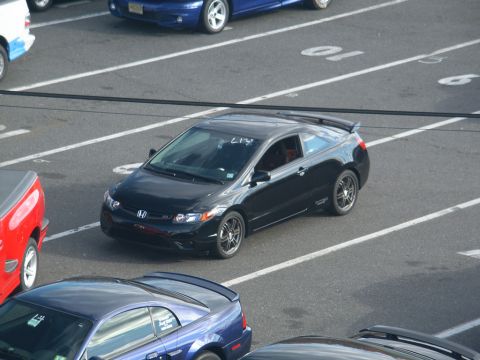 2001 Mercury Grand Marquis - A black Honda Civic coupe is parked in a lot alongside other vehicles.