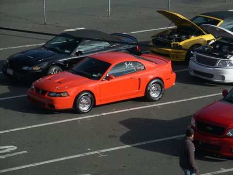 2001 Mercury Grand Marquis - Multiple vehicles are lined up, including an orange coupe with racing slicks and an R-4 decal on the door.