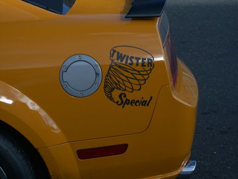 2001 Mercury Grand Marquis - Close-up of a yellow car's rear, showing a 'Twister Special' decal and a fuel filler door.