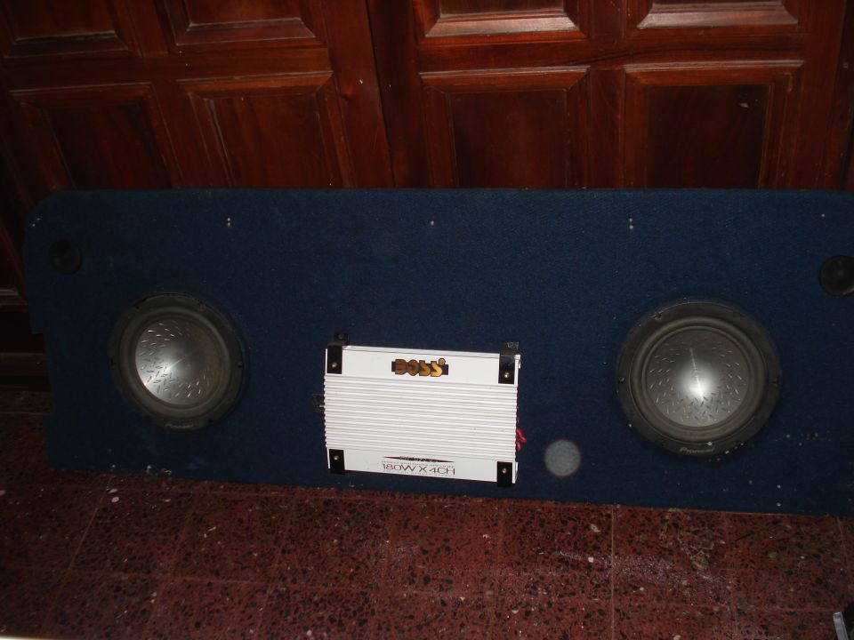 Blue carpeted car audio board with two Pioneer subwoofers and a white Boss 4-channel amp