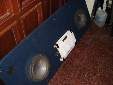 1986 Ford Bronco - A blue carpeted subwoofer box with two speakers and a white amplifier is shown.
