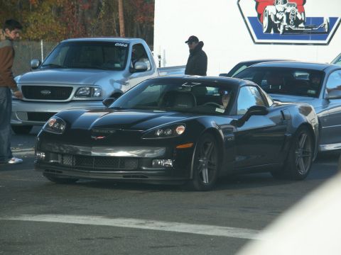 2001 Mercury Grand Marquis - A black Chevrolet Corvette is parked at an outdoor event with other vehicles visible.