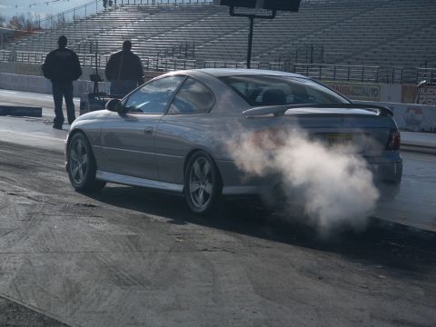 2001 Mercury Grand Marquis - Silver coupe performing a burnout at a drag strip.