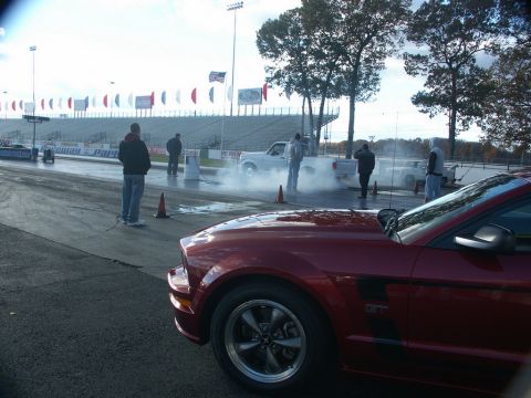 2001 Mercury Grand Marquis - Drag strip scene with a red GT Mustang and vehicles doing a burnout.