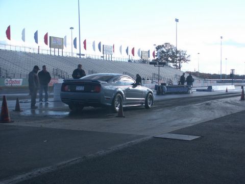 2001 Mercury Grand Marquis - A gray coupe sits on a drag strip, ready for a race. The stands are visible in the background.