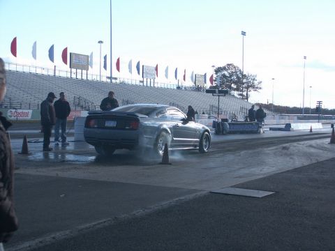 2001 Mercury Grand Marquis - A Ford Mustang performs a burnout at a drag strip, preparing for a race.