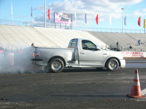 2001 Mercury Grand Marquis - Silver Ford F-150 Lightning truck performs a burnout at a drag racing event.