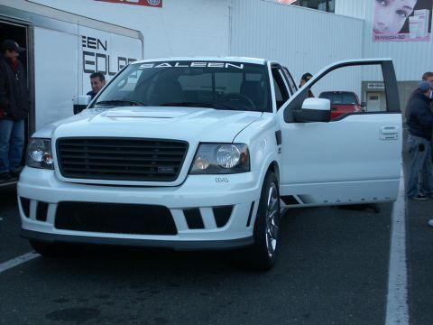 2001 Mercury Grand Marquis - A white Saleen F-150 pickup truck is shown with its driver's door open, Saleen branding on the windshield banner and side panels.