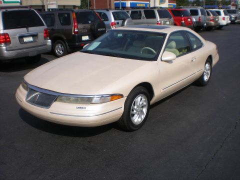 1995 Ford Thunderbird - Tan Lincoln Mark VIII coupe parked in a lot with other vehicles behind it.