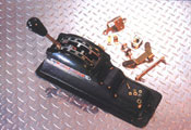 1980 Ford Bronco - An automatic transmission shifter assembly and associated hardware are displayed on a textured metal surface.