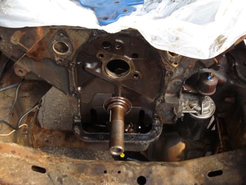 1967 Ford F-250 - Close-up of an engine block showing the crankshaft and oil pan area, with a fuel pump attached.