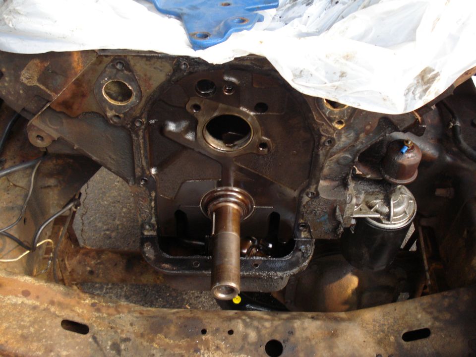 Engine block with crankshaft extending out, oil pan removed. Fuel pump visible on the side