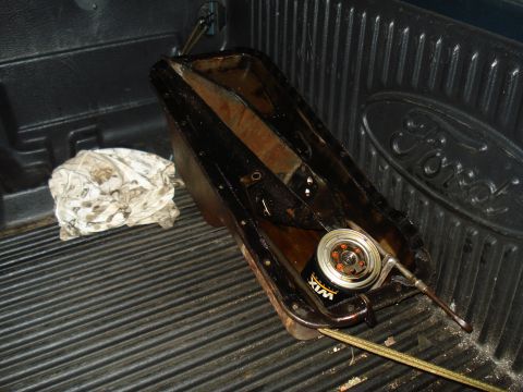 1967 Ford F-250 - Oil pan and Wix oil filter are in the bed of a Ford truck, next to a rag.