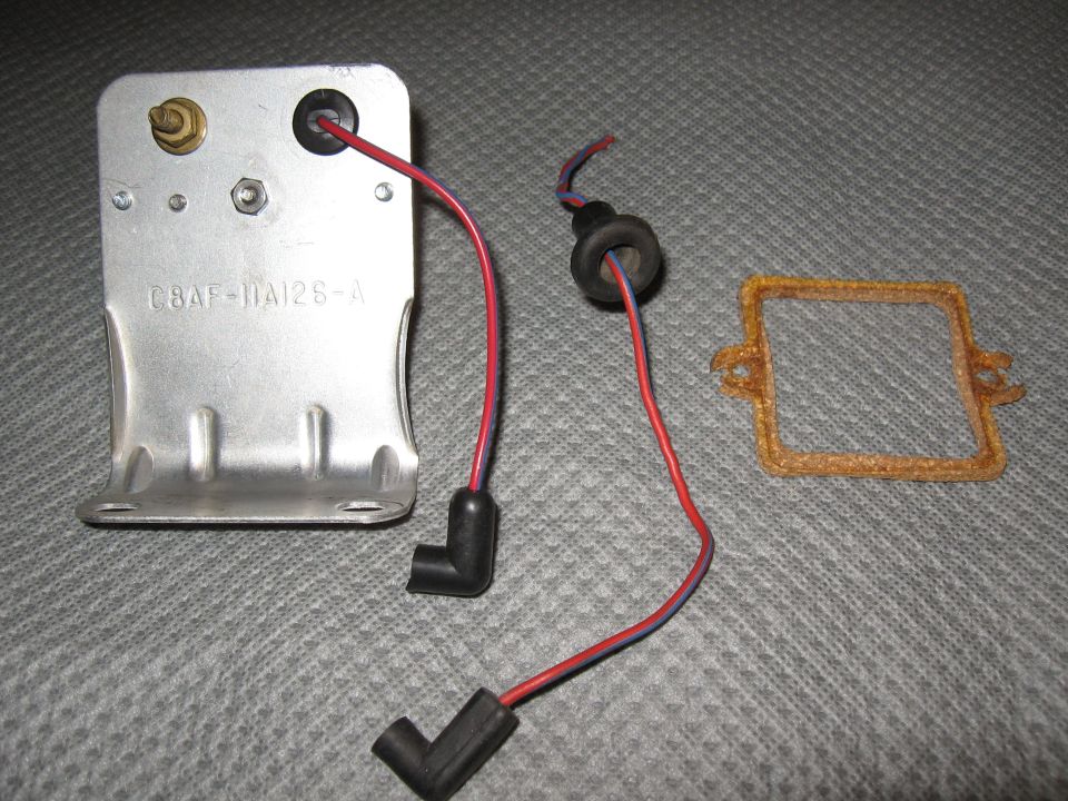 Metal starter delay relay with wires and a gasket on a gray surface. Part number C8AF-11A12S-A is visible