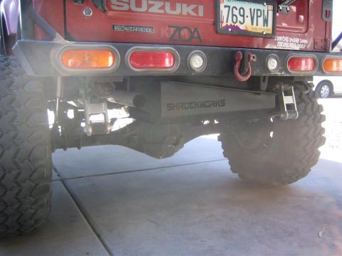 1987 Suzuki Samurai - Rear view of a 1987 Suzuki Samurai, highlighting the "SHROCKWORKS" skid plate and custom bumper with tow hitch.