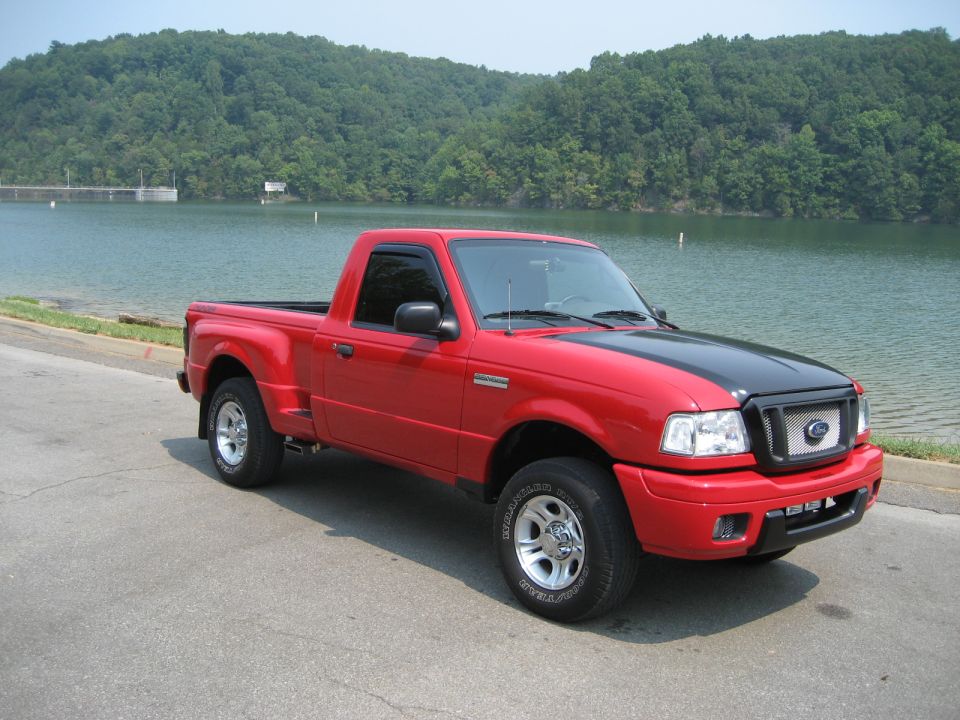 Red 2004 Ford Ranger pickup truck parked by a lake