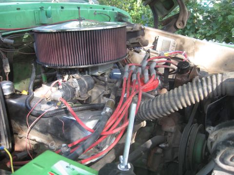 1979 Ford Bronco - Close-up view of an engine bay, red spark plug wires and a prominent air filter.