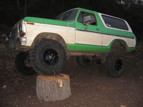 1979 Ford Bronco - This modified Bronco is shown with its front tire resting on a large tree stump.