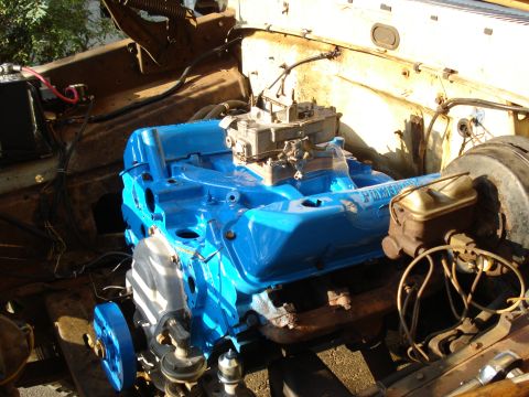 1967 Ford F-250 - The engine bay of a vehicle, a freshly painted blue engine block and various components.