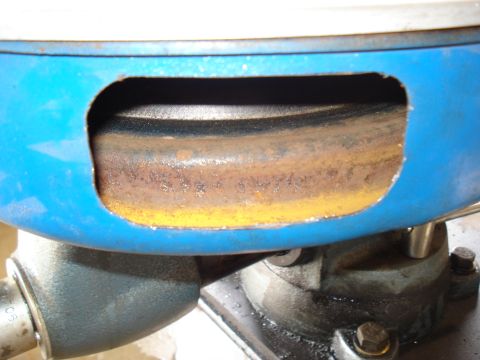 1967 Ford F-250 - A close-up view of a rusty component within a blue housing, likely part of an engine or machinery.