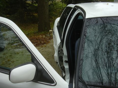 1997 Ford Crown Victoria - The driver's side doors of a white 1997 Ford Crown Victoria are open, revealing the interior and exterior.