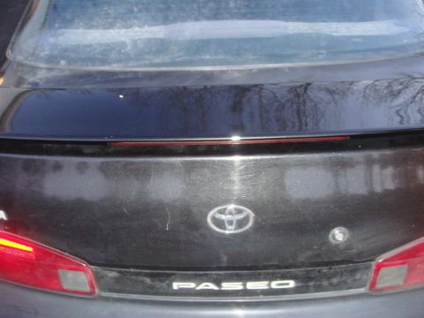 1996 Ford Bronco - The rear of a Toyota Paseo is shown, the brand emblem and model name.