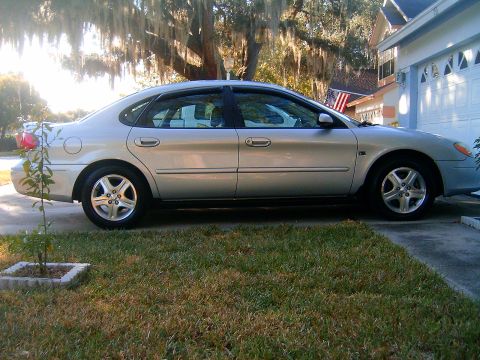 2002 Ford Taurus - Side profile of a silver 2002 Ford Taurus sedan parked in a driveway.