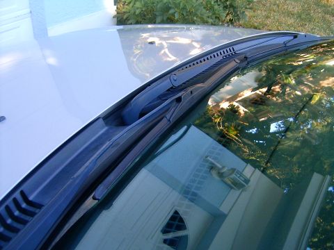 2002 Ford Taurus - Windshield wiper assembly detail on a car's hood.