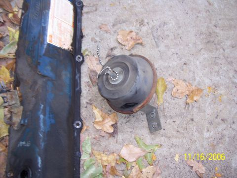 1978 Ford Bronco - Overhead shot of removed engine parts lying on a leaf-strewn concrete driveway, dated 11/16/2006. A dark blue Ford-script stamped steel val…
