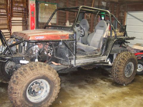 1989 Ford Bronco - Custom buggy with roll cage and racing seats. Text on hood reads 'PRO-TECH HELP Suzuki'.