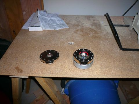 1996 Ford Probe - Two steering wheel quick release hubs are on a workbench with some papers and tools.