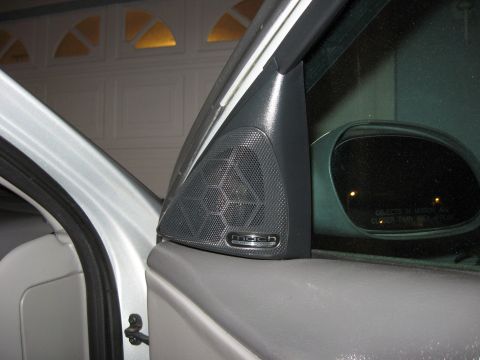 2002 Ford Taurus - Close-up of a Mach audio speaker on a car's interior door panel.