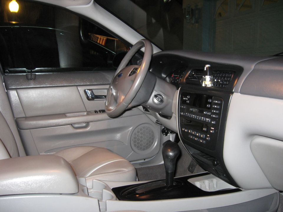 Interior view of a 2002 Ford Taurus showing the dashboard, steering wheel, center console, and door panel