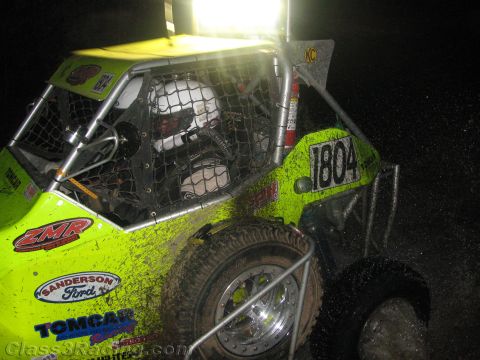 1990 Ford Bronco - bright green tube-frame off-road buggy numbered 1804, splattered with mud and fitted with a roof light, sits at night.