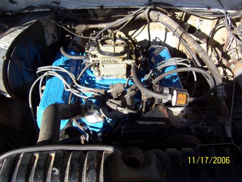 1978 Ford Bronco - Overhead engine bay shot of a Ford V8 painted Ford corporate blue with "Powered by Ford" valve covers, topped by a Holley four-barrel carbu…