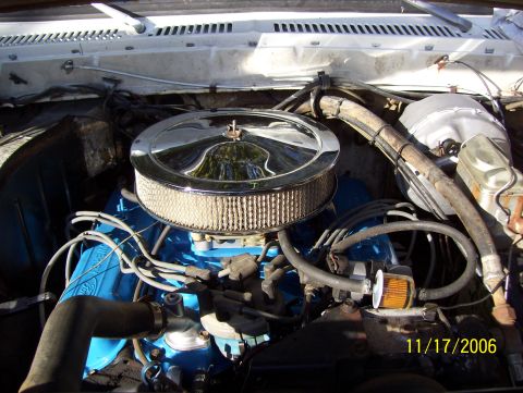 1978 Ford Bronco - The engine bay features a blue engine block and a chrome air filter housing, with visible hoses and wiring.