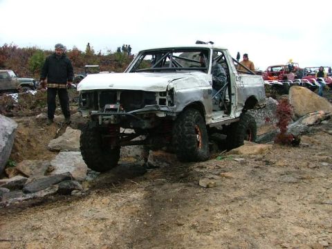 1995 Ford Bronco - This heavily modified truck appears to be participating in an off-road event, with other vehicles visible in the background.