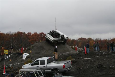 1995 Ford Bronco - Off-road vehicles navigate a challenging course with spectators watching.